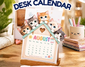May include: A 2027 desk calendar featuring a house-shaped frame with four illustrated kittens peering over the roof. The calendar page displays the month of August with a sun, rainbow, and starfish graphic. The text reads 2027 DESK CALENDAR.