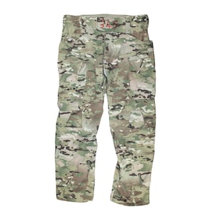 Peut inclure: Pantalon cargo camouflage avec plusieurs poches. Le pantalon a une étiquette rouge avec le numéro "34S" sur la ceinture.