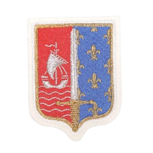 May include: A white embroidered patch with a gold border. The patch features a red and blue shield with a white ship, a sword, and three fleur-de-lis.