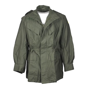 Puede incluir: Una chaqueta verde de estilo militar con cierre de cremallera, dos bolsillos grandes y cintura con cordón.