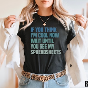 May include: Black t-shirt with the text "If you think I'm cool now wait until you see my spreadsheets" in a blue and green gradient.