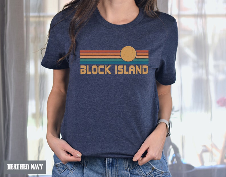 May include: A heather navy blue t-shirt with a retro-style graphic of a sunset over a beach with the text "BLOCK ISLAND" in white.