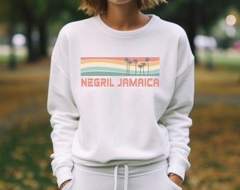 May include: White sweatshirt with a retro-style graphic of palm trees and the text "Negril Jamaica".