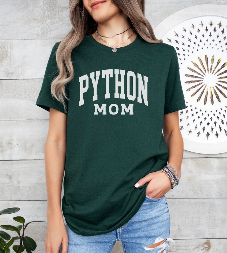 Peut inclure: Un t-shirt vert fonc&eacute; avec le texte "PYTHON MOM" en lettres blanches.