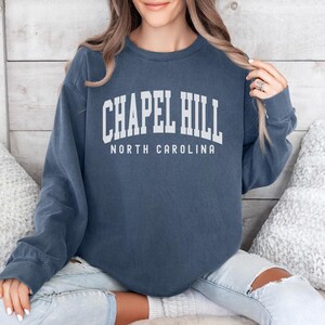 May include: A navy blue sweatshirt with the text "Chapel Hill North Carolina" in white lettering.