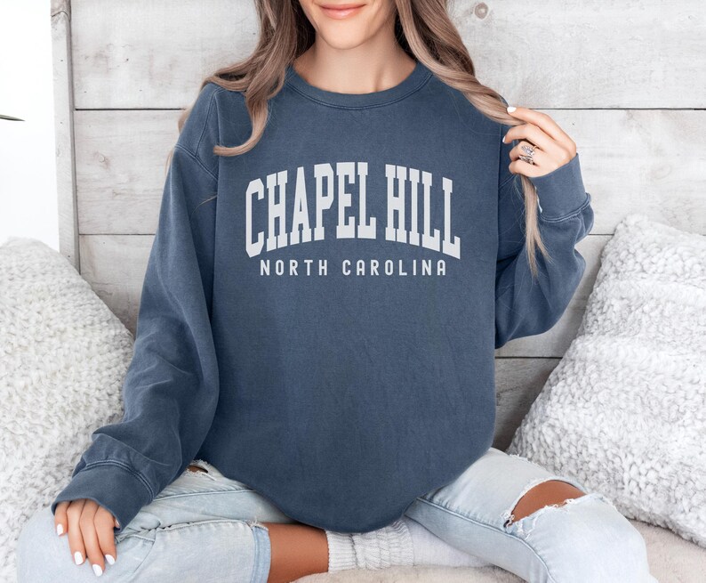 May include: A navy blue sweatshirt with the text "Chapel Hill North Carolina" in white lettering.