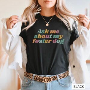 May include: Black t-shirt with the text "Ask me about my foster dog" in colorful retro font.