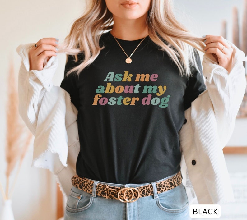 May include: Black t-shirt with the text "Ask me about my foster dog" in colorful retro font.