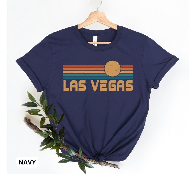 May include: Navy blue t-shirt with a retro sunset graphic and the text "LAS VEGAS" in a vintage font.
