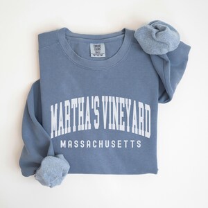 May include: A blue sweatshirt with white text that reads "Martha's Vineyard Massachusetts".