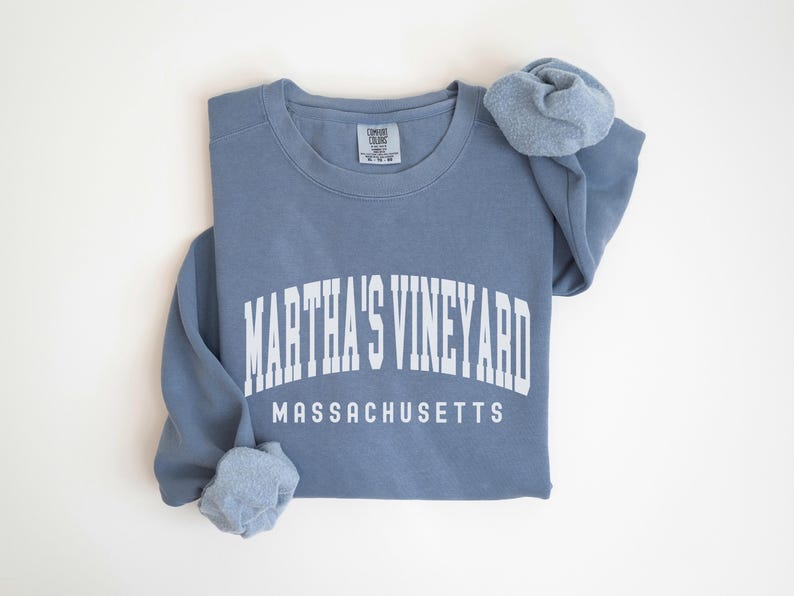 May include: A blue sweatshirt with white text that reads "Martha's Vineyard Massachusetts".