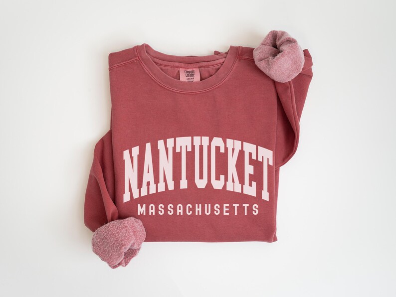 May include: A maroon sweatshirt with the text "NANTUCKET MASSACHUSETTS" in white.