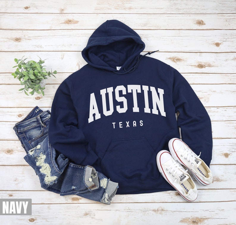 May include: Navy blue hooded sweatshirt with white text that reads "Austin Texas".