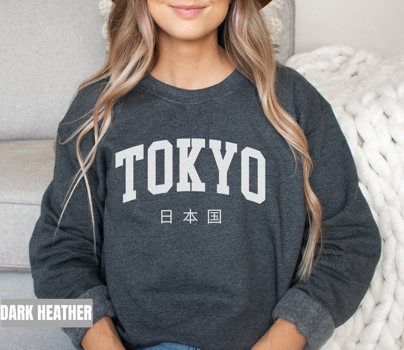 May include: Dark heather grey sweatshirt with the word "TOKYO" in white block letters and the Japanese characters for "Japan" underneath.
