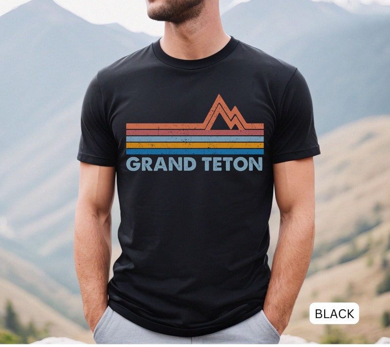 Puede incluir: Camiseta negra con un gr&aacute;fico retro de una cordillera y el texto "GRAND TETON" en blanco.