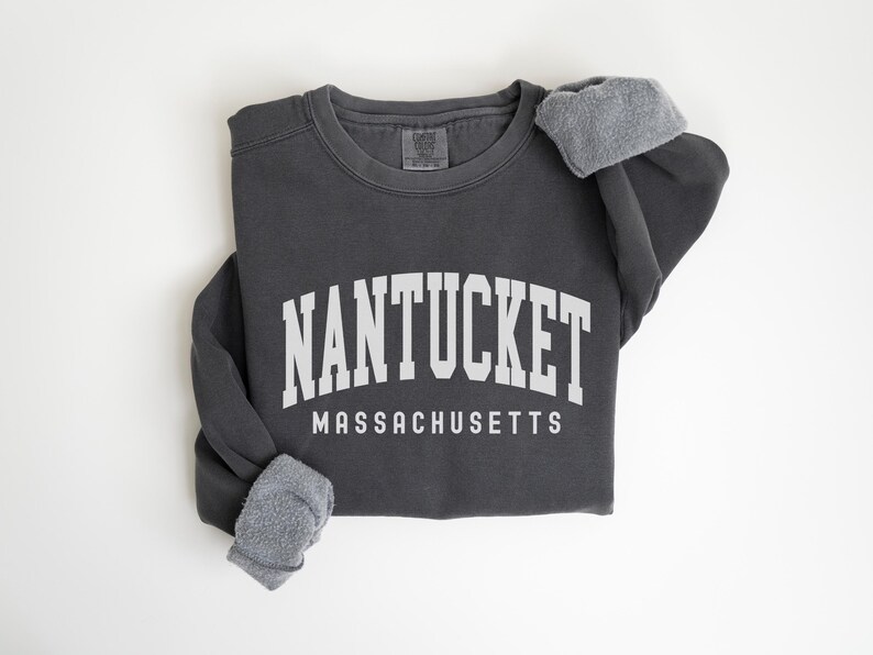 May include: A dark gray sweatshirt with the text "NANTUCKET MASSACHUSETTS" in white.