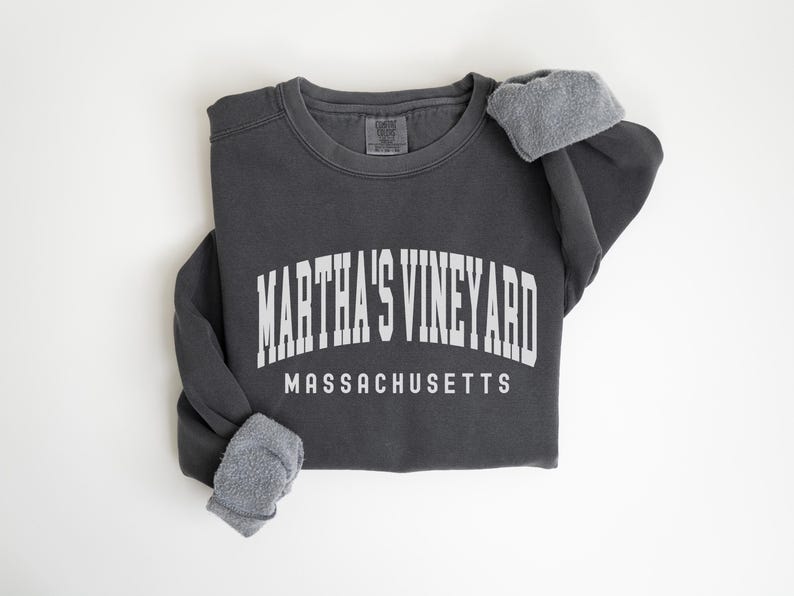 May include: A charcoal gray sweatshirt with the text "MARTHA'S VINEYARD MASSACHUSETTS" in white.