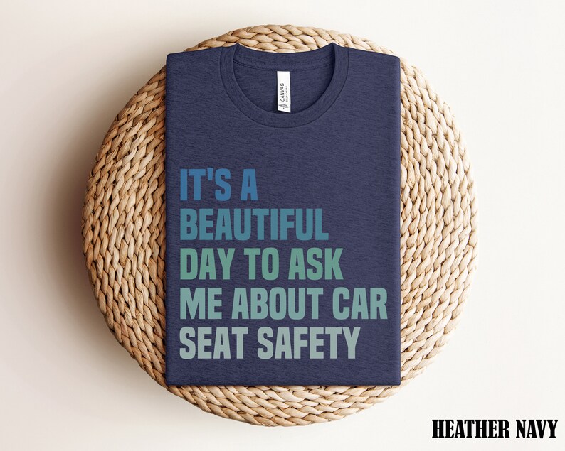 K&ouml;nnte beinhalten: T-Shirt in Dunkelblau mit dem Text "It's a beautiful day to ask me about car seat safety" in einem Farbverlauf von Blau, Gr&uuml;n und T&uuml;rkis.