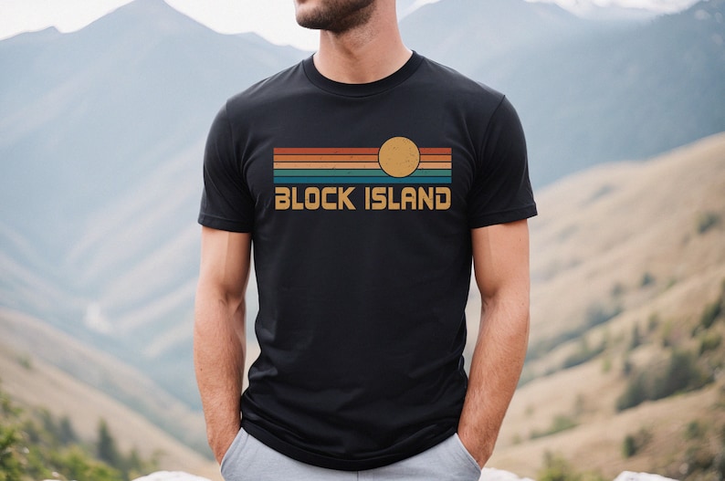 May include: A black t-shirt with a retro-style graphic design featuring a sunset with a yellow sun and the text "BLOCK ISLAND".
