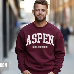 May include: Maroon sweatshirt with white text that reads "ASPEN COLORADO"