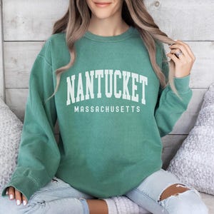 May include: A green sweatshirt with the text "NANTUCKET MASSACHUSETTS" in white.