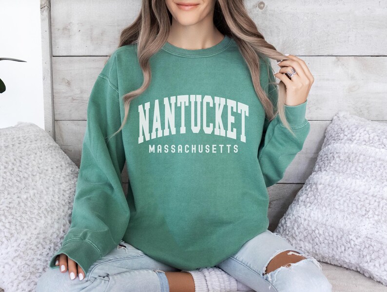 May include: A green sweatshirt with the text "NANTUCKET MASSACHUSETTS" in white.