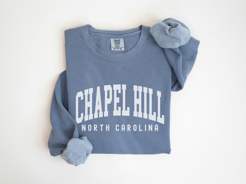 May include: A blue sweatshirt with the text "Chapel Hill North Carolina" in white.