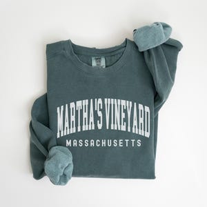 May include: A teal blue sweatshirt with the text "Martha's Vineyard Massachusetts" in white.