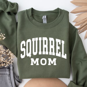 May include: A green sweatshirt with white text that reads "Squirrel Mom".