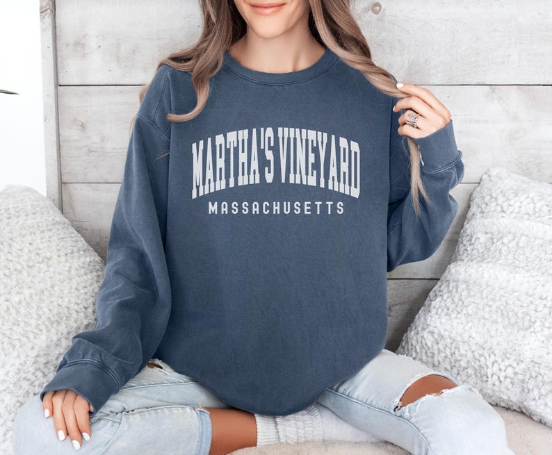 May include: A navy blue long-sleeved sweatshirt with the text "Martha's Vineyard Massachusetts" printed in white.
