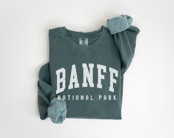 May include: A teal blue sweatshirt with the text "BANFF NATIONAL PARK" in white.