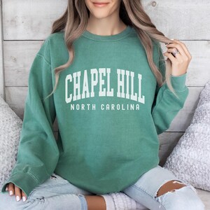 May include: A green sweatshirt with the text "Chapel Hill North Carolina" in white.