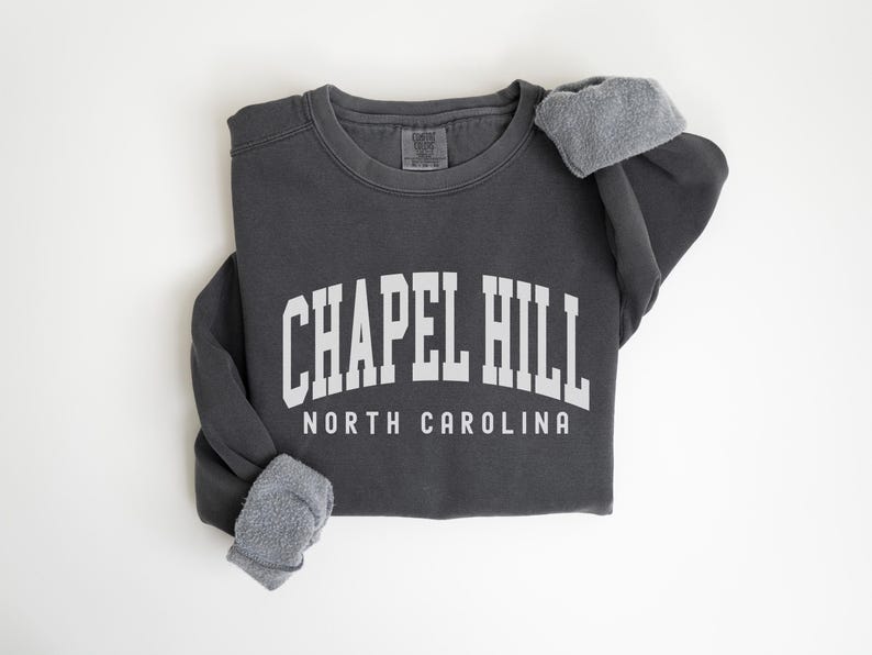 May include: A charcoal gray sweatshirt with the text "CHAPEL HILL NORTH CAROLINA" in white.