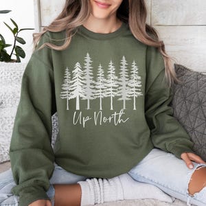 May include: A green sweatshirt with a white graphic of pine trees and the text "Up North".
