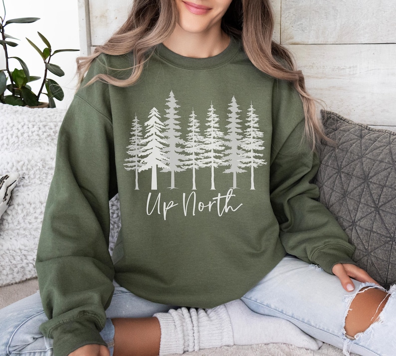 May include: A green sweatshirt with a white graphic of pine trees and the text "Up North".