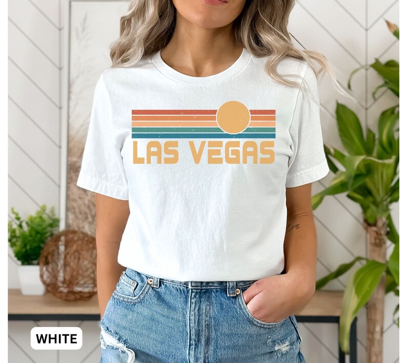 May include: White t-shirt with a retro sunset graphic and the text "LAS VEGAS" in yellow.