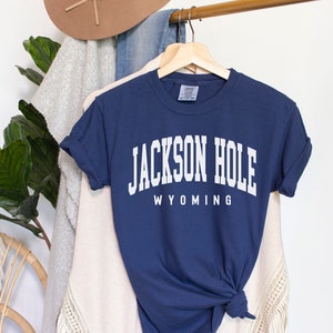 May include: A navy blue t-shirt with white text that reads "JACKSON HOLE WYOMING".