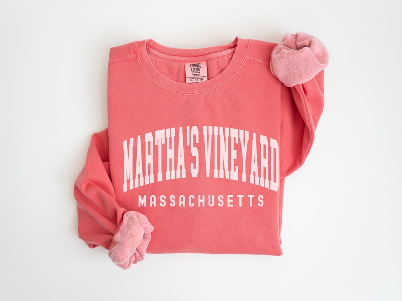 May include: A coral pink sweatshirt with the text "MARTHA'S VINEYARD MASSACHUSETTS" in white.