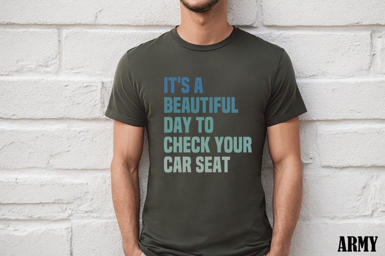 May include: A dark green t-shirt with the text "It's a beautiful day to check your car seat" in a gradient of blue and green.