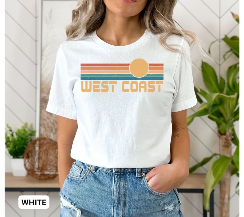 May include: White t-shirt with a retro sunset graphic and the text "West Coast" in orange.