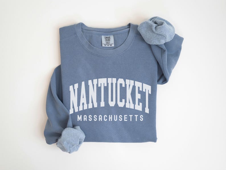 May include: A blue sweatshirt with the text "NANTUCKET MASSACHUSETTS" in white.