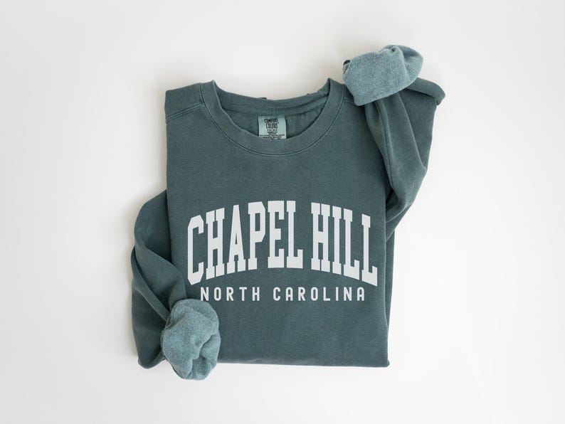 May include: A teal blue sweatshirt with the text "Chapel Hill North Carolina" in white.