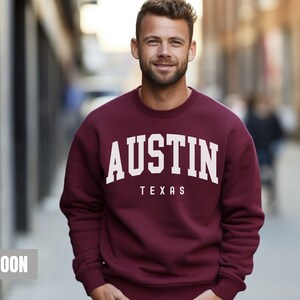 May include: Maroon sweatshirt with white text that reads "AUSTIN TEXAS".