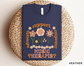 Könnte beinhalten: T-Shirt in Dunkelblau mit einem Blumenmuster und dem Text "Support, Advocate, Empower, Music Therapist".