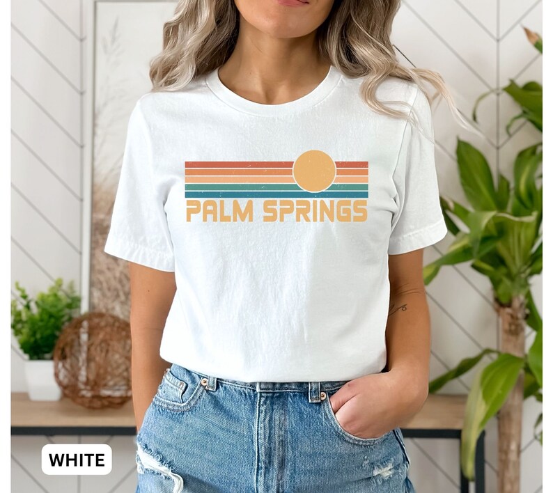 May include: White t-shirt with a retro sunset graphic and the text "PALM SPRINGS" in a vintage font.