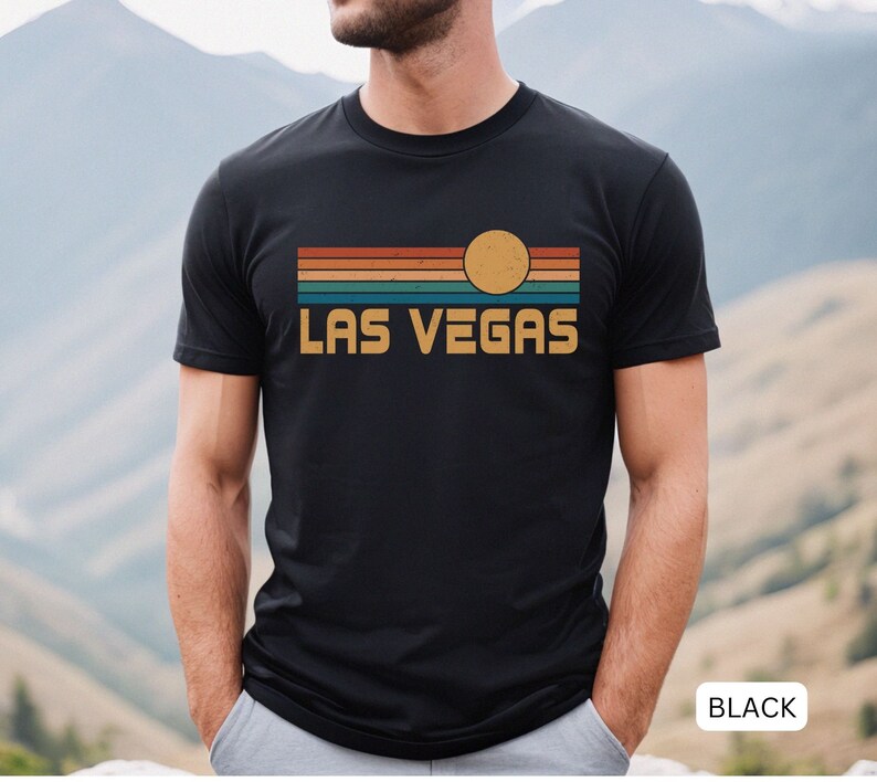 May include: Black t-shirt with a retro sunset graphic and the text "LAS VEGAS" in yellow.