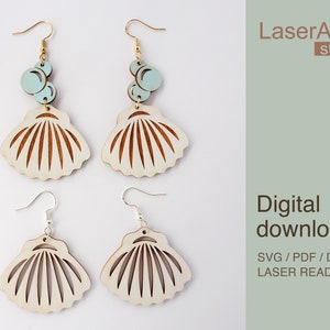May include: Two pairs of laser cut wooden earrings featuring a seashell design. The top pair has a light blue circle charm with a smaller circle charm inside. The bottom pair has a simple silver hook. The text "LaserArtist studio" and "Digital download SVG / PDF / DXF LASER READY FILES" is visible in the image.
