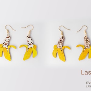 May include: A pair of yellow banana earrings with a brown and white leopard print design. The earrings are made of wood and have gold hooks.
