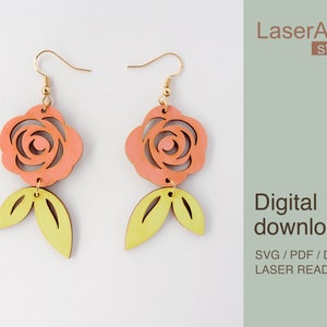 May include: A pair of laser cut wooden earrings featuring a pink rose with a yellow leaf design. The earrings are labeled "Digital download SVG/PDF/DXF Laser Ready Files" and "LaserArtist studio".