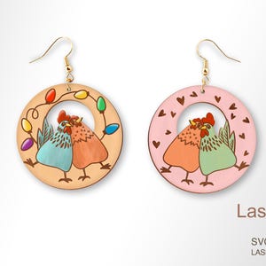 May include: A pair of wooden earrings with a pink and a beige circle. Each circle features a pair of chickens with a string of lights or hearts around them. The earrings are laser cut and ready to be assembled.